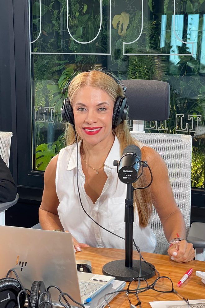 Cynthia Noguera con auriculares al micrófono en el estudio de La Tribu 650 AM